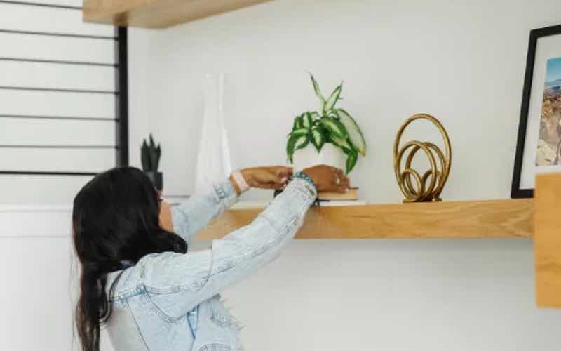 A little girl dusting her shelves, a cleaning process encouraged by Zerorez.